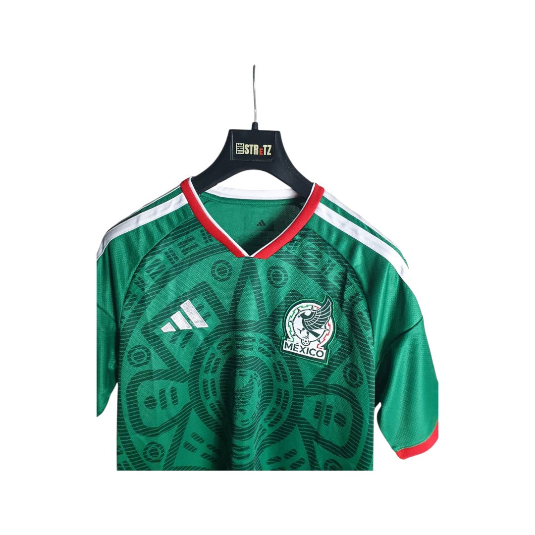 Green soccer jersey with red and white accents on a hanger against a white background