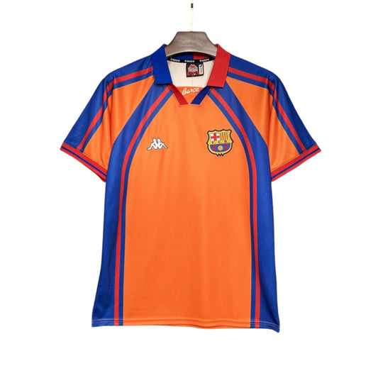 FC Barcelona 1998/1999 away jersey displayed on a mannequin, featuring orange and blue colors with geometric patterns.