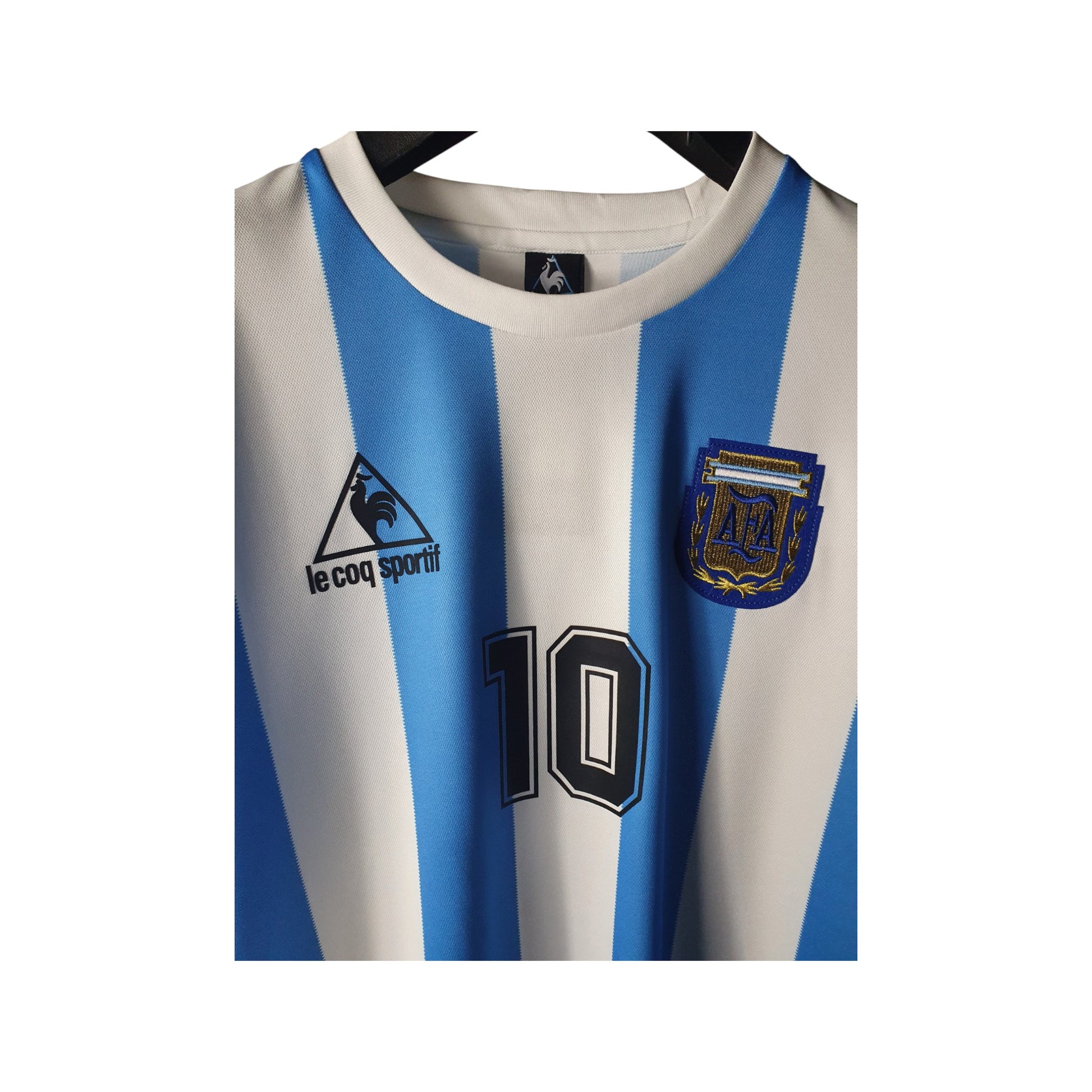 Argentina Home sports jersey with blue and white stripes, number 10, and Le Coq Sportif logo.