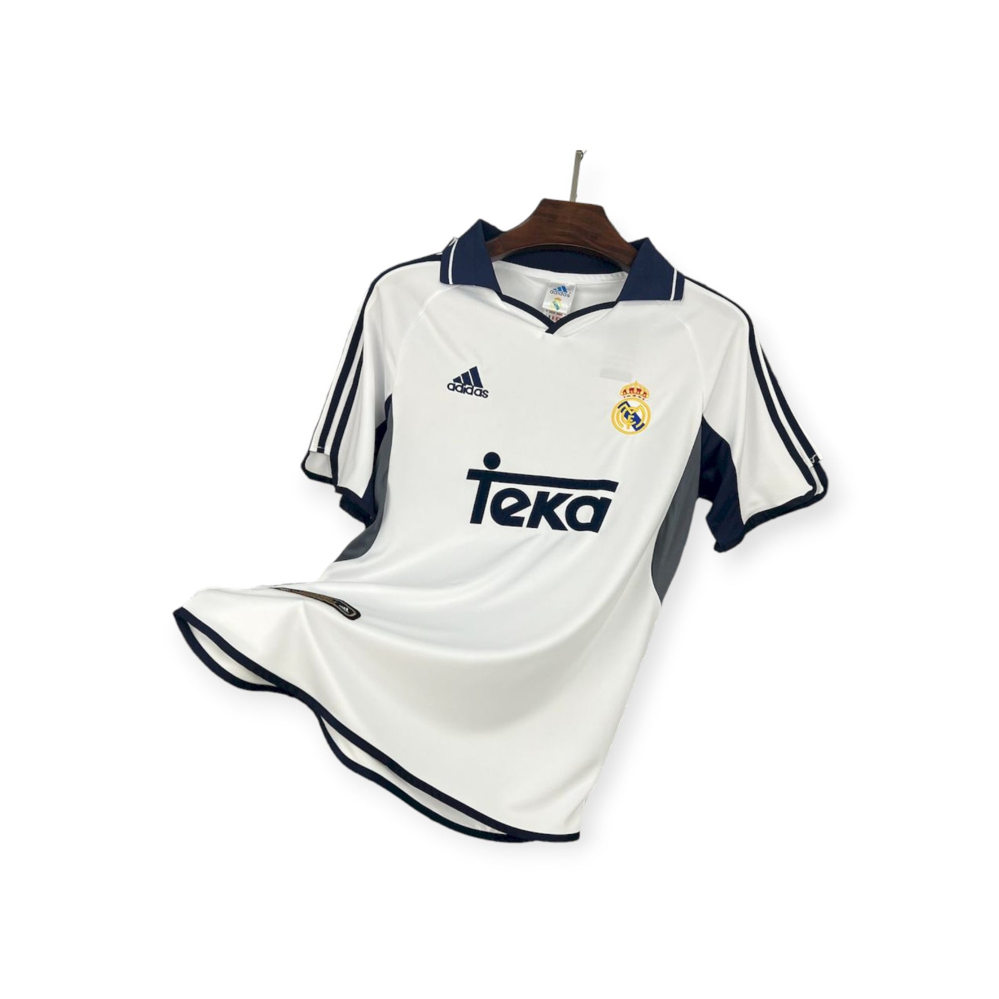 Real Madrid 2000/01 Home Jersey displayed on a wooden hanger, predominantly white with navy blue details, adidas brand logo, and Teva sponsor logo.
