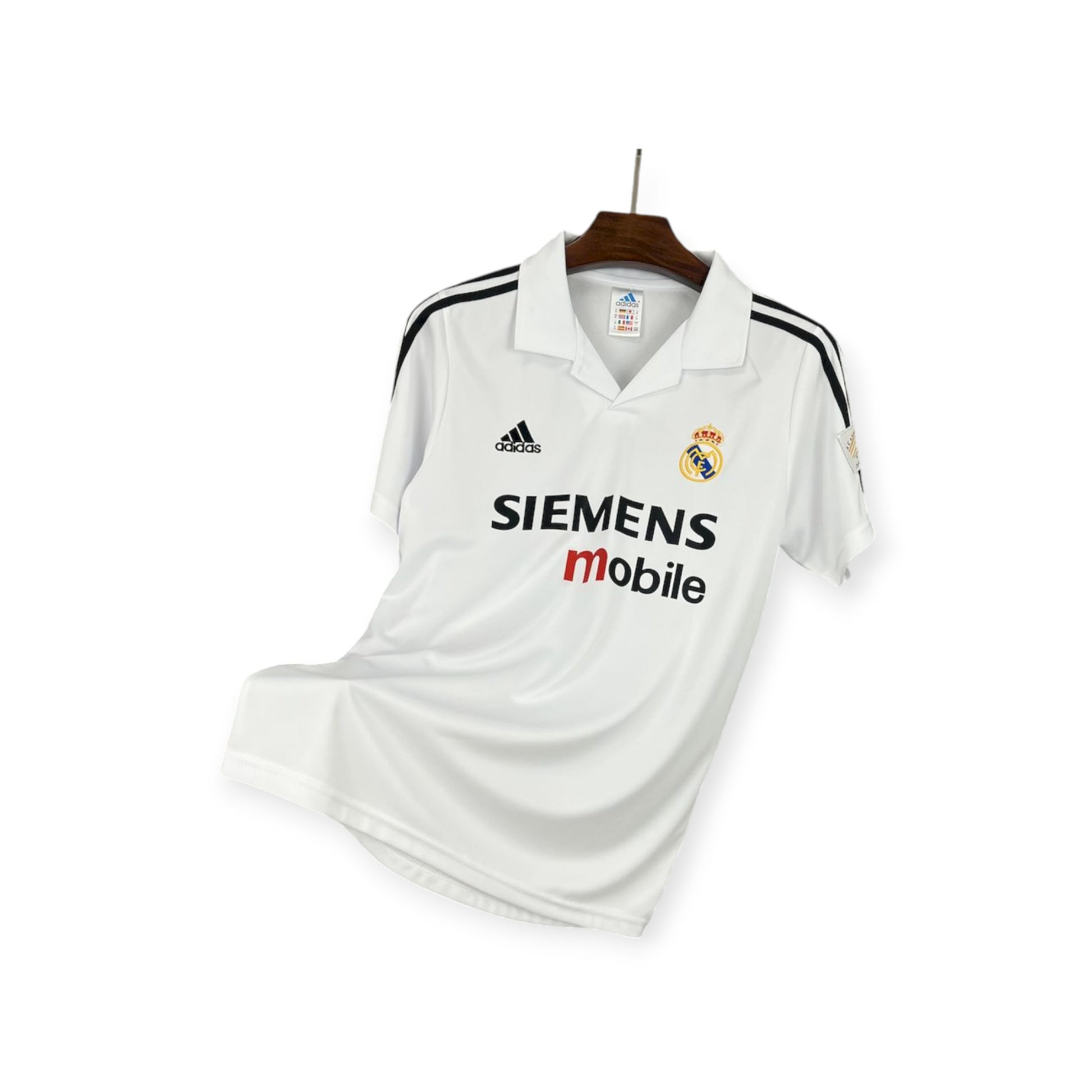 Real Madrid 2002/2003 Home Jersey displayed on a hanger, predominantly white with gold details, and sponsor logos including 'SIEMENS mobile'.