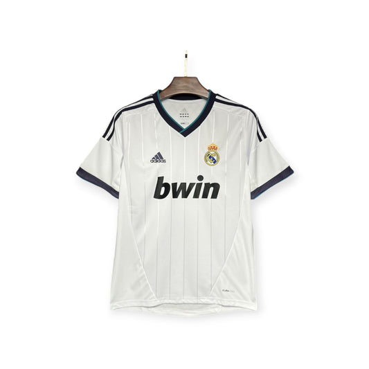 Real Madrid 2012/2013 Home Jersey displayed on a mannequin, featuring white color with blue and black accents, the club crest, and the bwin sponsor logo.