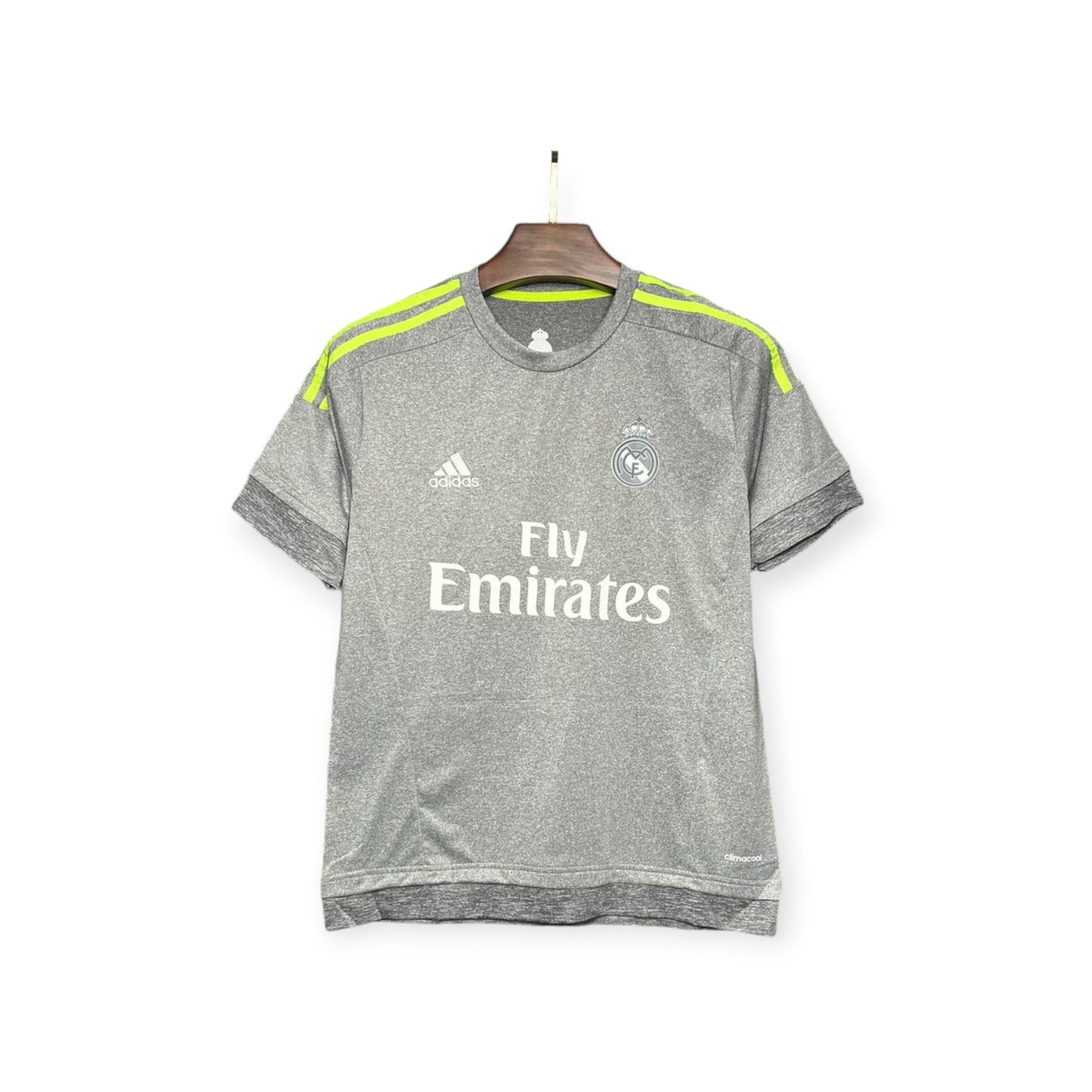 Real Madrid 2015/2016 Away Jersey displayed on a hanger, gray with yellow accents and 'Fly Emirates' text on the front.