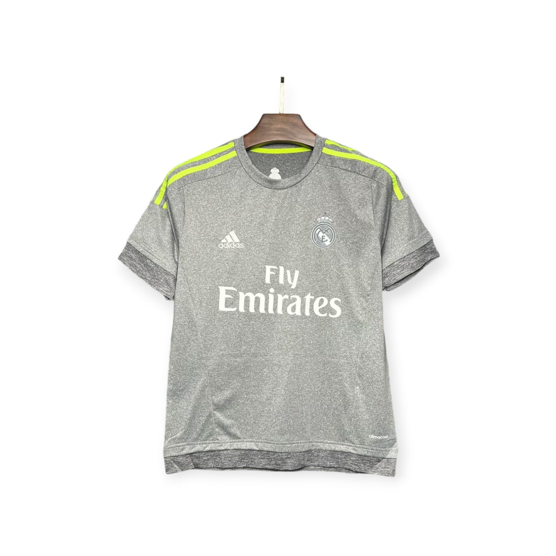 Real Madrid 2015/2016 Away Jersey displayed on a hanger, gray with yellow accents and 'Fly Emirates' text on the front.